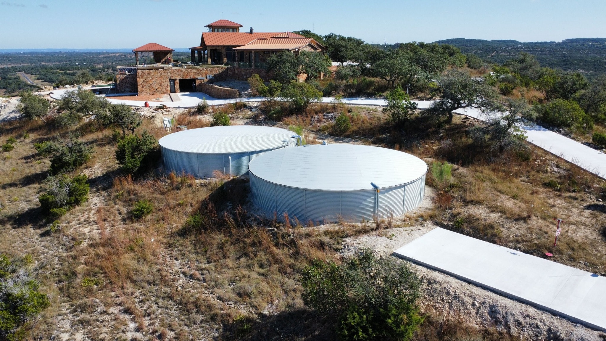Aerial view of twin Pioneer water storage tanks at rural Texas property